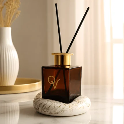 Luxury diffuser White Sandalwood σε γυάλινο Dark Amber μπουκάλι με χρυσό καπάκι πάνω σε λευκή βάση πορσελάνης Marble Gold
